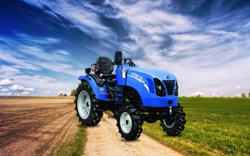 New Holland Simba 30 tractor on a dirt road, ideal for versatile farming applications with powerful performance.